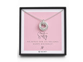 A silver ring pendant displayed inside a black gift box on a pink card that reads 'Sixty' and 'Six Rings for Six Decades. Happy Birthday!'.