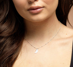 Model wearing sterling silver angel wing guardian necklace.