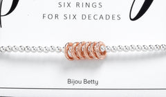 Close up of 60th milestone birthday bracelet, sterling silver, 6 rose gold rings.