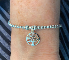Model wearing Bijou Betty’s 925 silver tree of life bracelet, 3mm and 5mm beads, 14mm charm, stretch-fit.