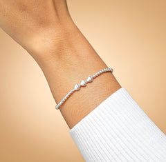 Model wearing sterling silver mum heart bracelet.