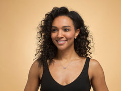 Model wearing sterling silver team leaving heart necklace.