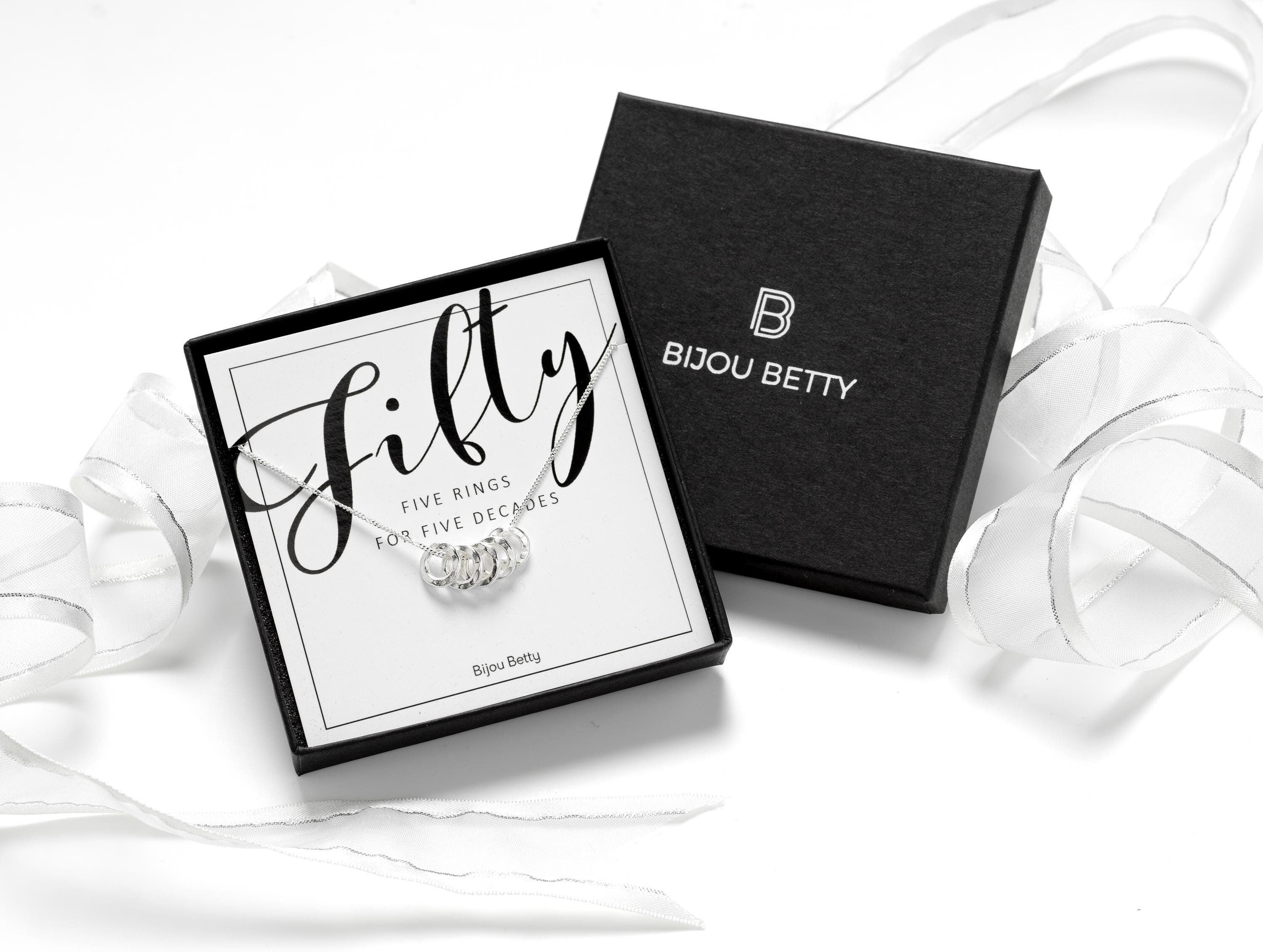 Solid sterling silver 50th birthday necklace featuring 5 hammered rings, each symbolising a decade. Comes with a choice of 16, 18, or 20-inch chain. Includes a gift box, bag, and tissue paper, perfect for celebrating 5 decades of life.