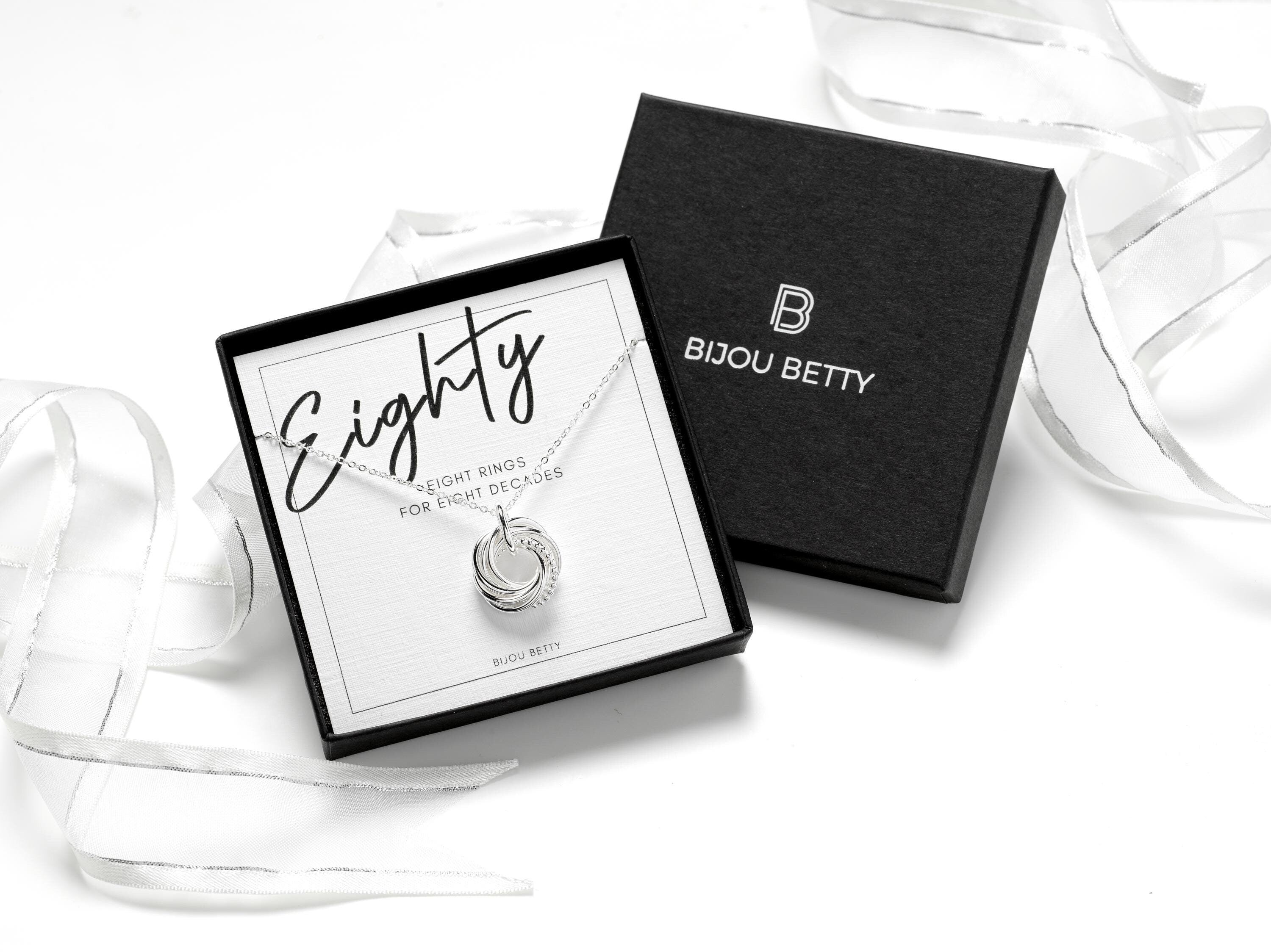 Elegant sterling silver necklace with 8 interlocking rings, each symbolising a decade, including one textured bobble ring. A meaningful 80th birthday milestone gift for mum, grandma, or loved ones, beautifully presented in a gift box and gift bag.