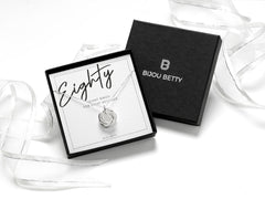 Elegant sterling silver necklace with 8 interlocking rings, each symbolising a decade, including one textured bobble ring. A meaningful 80th birthday milestone gift for mum, grandma, or loved ones, beautifully presented in a gift box and gift bag.