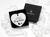 Ceramic heart keepsake with black satin ribbon, featuring the message My Bestie is Growing a Baby Bestie! Perfect pregnancy gift for best friend. Includes tissue wrapping and optional gift box for a thoughtful presentation.