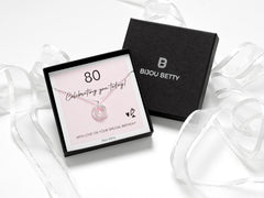 Sterling silver 80th birthday three-ring CZ necklace in a gift box.