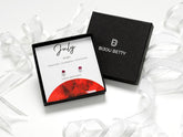 Sterling silver July birthstone ruby CZ stud earrings in Bijou Betty gift box.