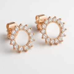 Close up of rose gold plated sunburst stud earrings.