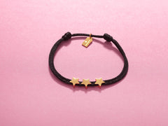 Close-up of 14k gold-plated star charms on black cord bracelet, perfect for a 30th milestone celebration.
