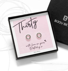 Close up of 30th birthday jewellery—silver open circle studs with black cubic zirconia studs.