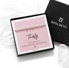 Close-up of Bijou Betty’s 925 silver 30th birthday bracelet with three heart pendants and 3mm beads, stretch-fit, in gift box.