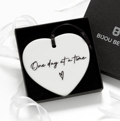 Close-up of 75mm ceramic heart with black ribbon, perfect for encouragement gifts for friends or sisters.