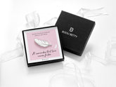 When feathers appear sympathy gift. A white feather enamel pin badge in a gift box.
