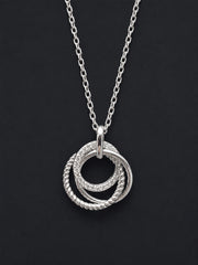 A silver 21st  pendant necklace featuring three interlocking rings, with two of the rings set with small clear stones and one twisted rope-style ring, displayed on a dark background.