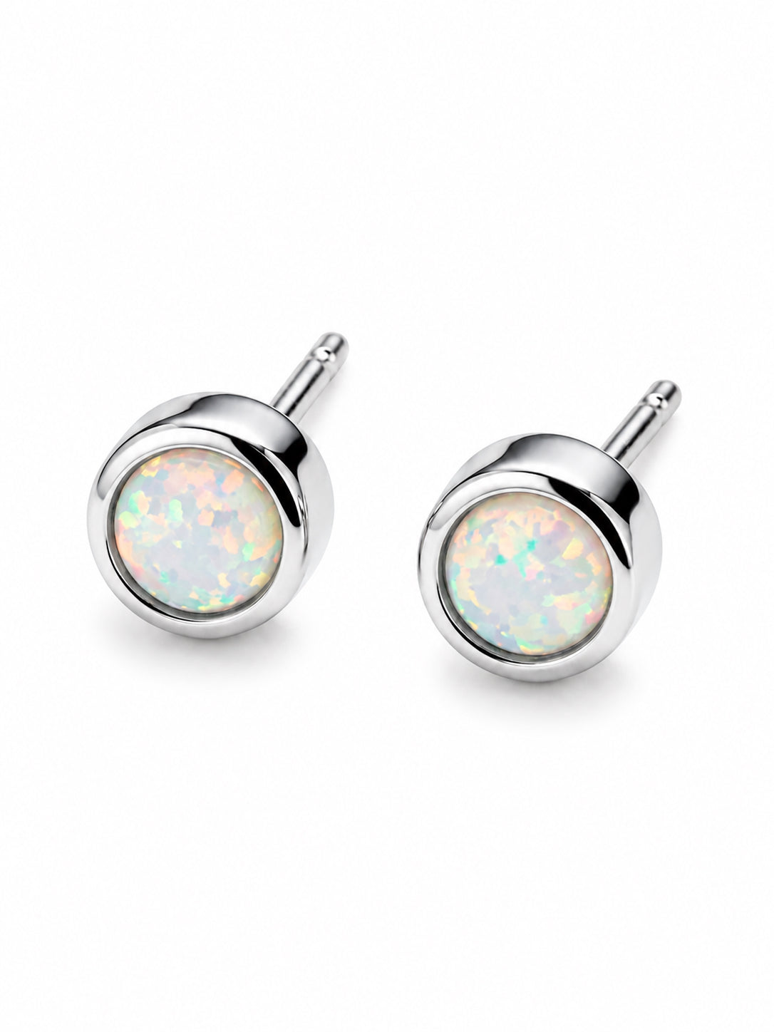Pair of silver stud earrings with opal-like gemstones on a white background. Opa; birthstone studs