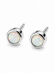 Pair of silver stud earrings with opal-like gemstones on a white background. Opa; birthstone studs
