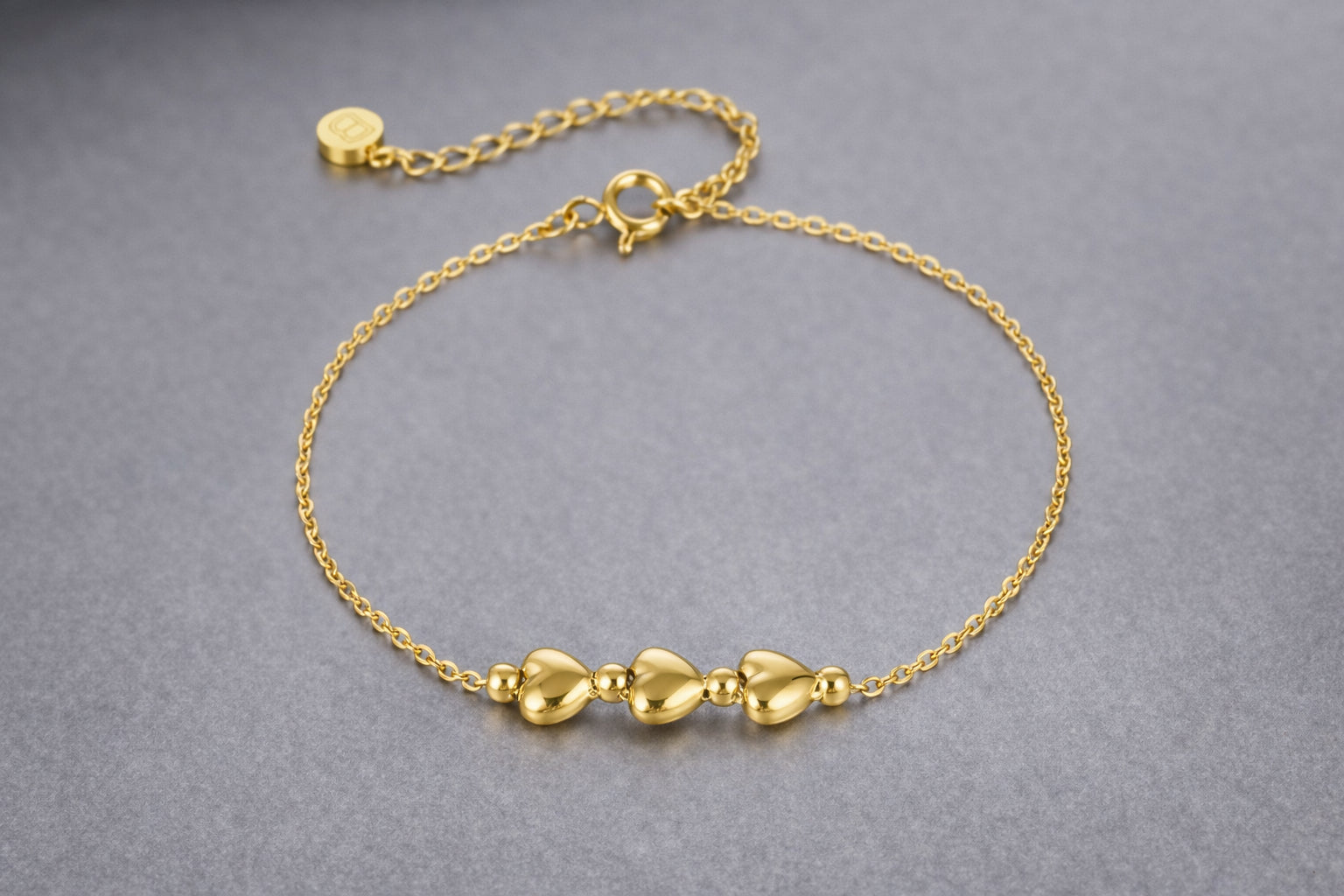 Gold-plated 3 heart bracelet on wrist, 16–20cm, Bijou Betty 21st birthday gift.