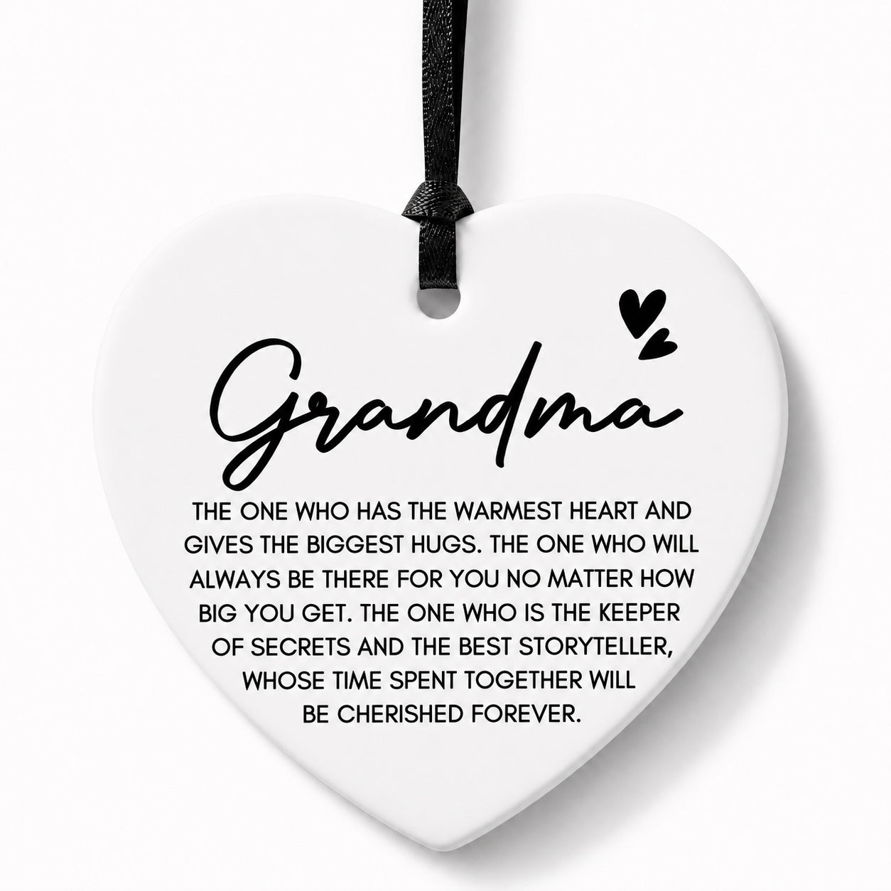 A white heart-shaped ceramic ornament with a black hanging ribbon, featuring the word 'Grandma' in script and a sentimental quote printed below in black text on a light gray background.