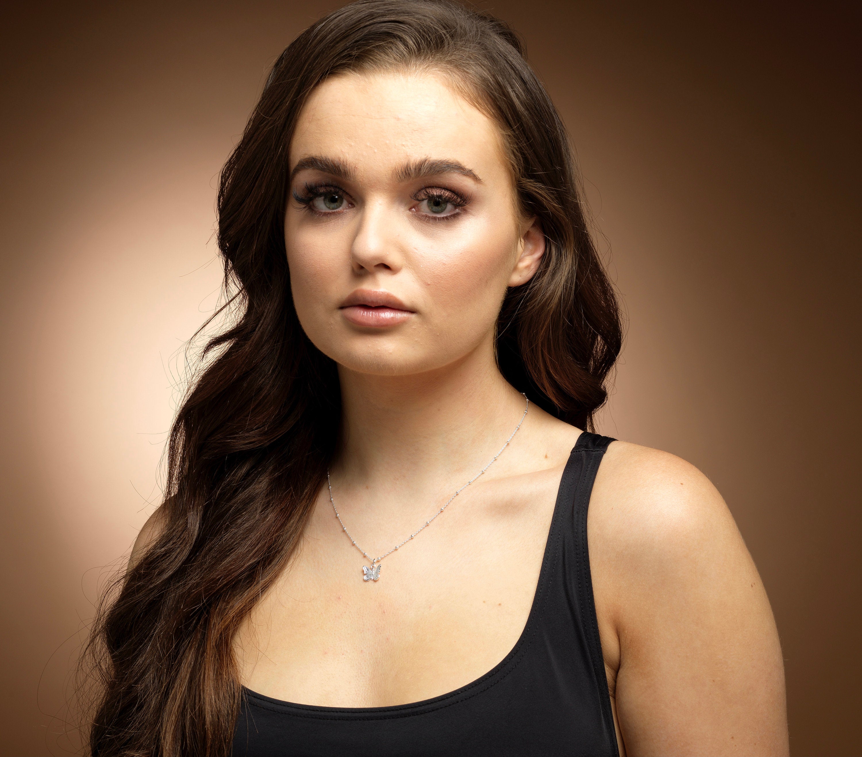 Model wearing Bijou Betty’s 925 silver butterfly necklace, 13mm x 11mm pendant on 16–20 inch chain, styled elegantly.