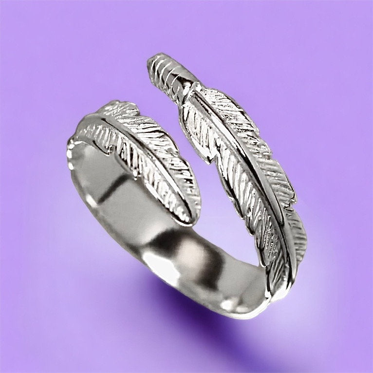 A close up of silver feather wrap ring.