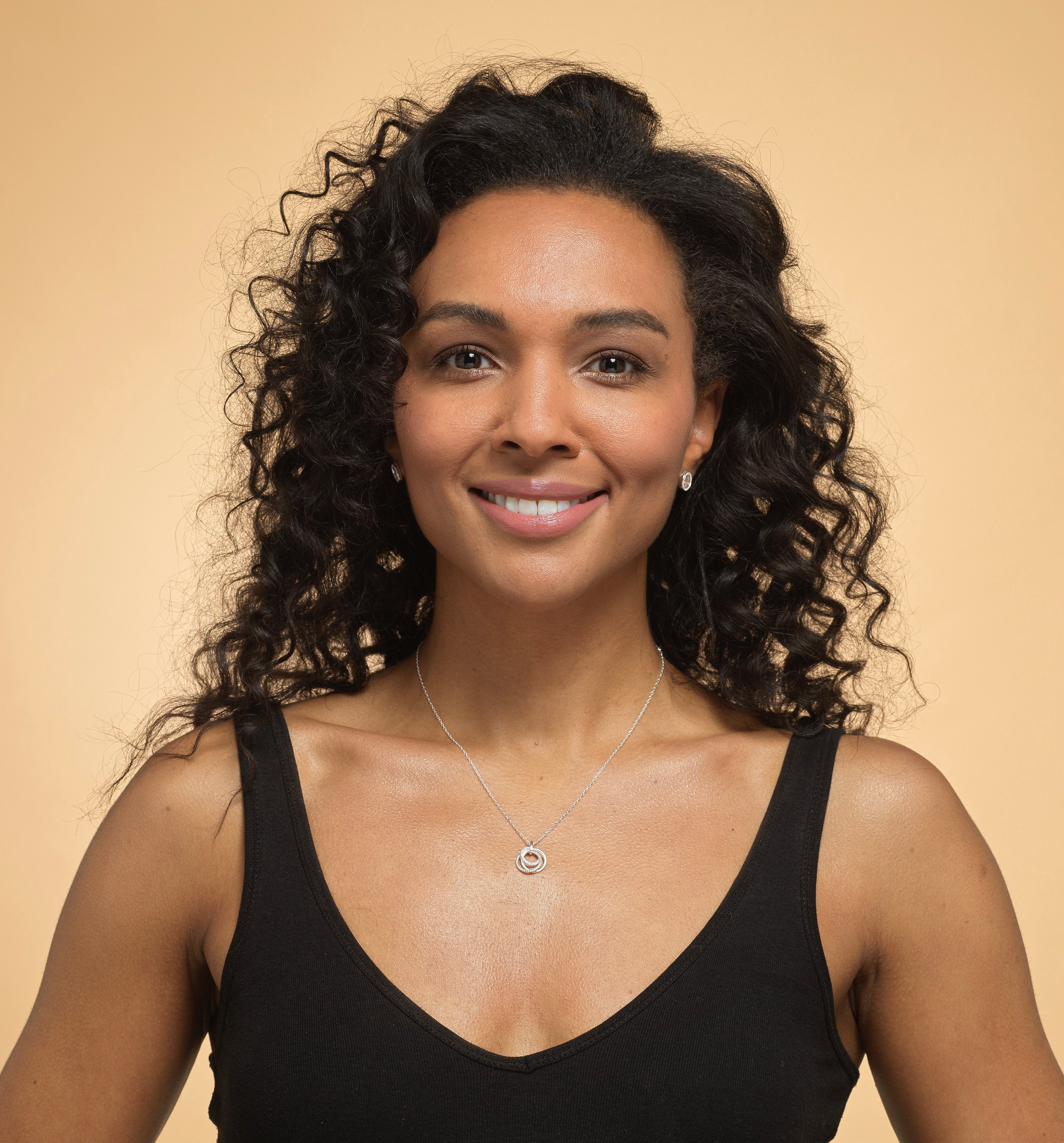 Model wearing Bijou Betty’s 925 sterling silver daughter necklace, featuring three interlinked rings with cubic zirconia, on a 16–18 inch adjustable chain, styled elegantly.
