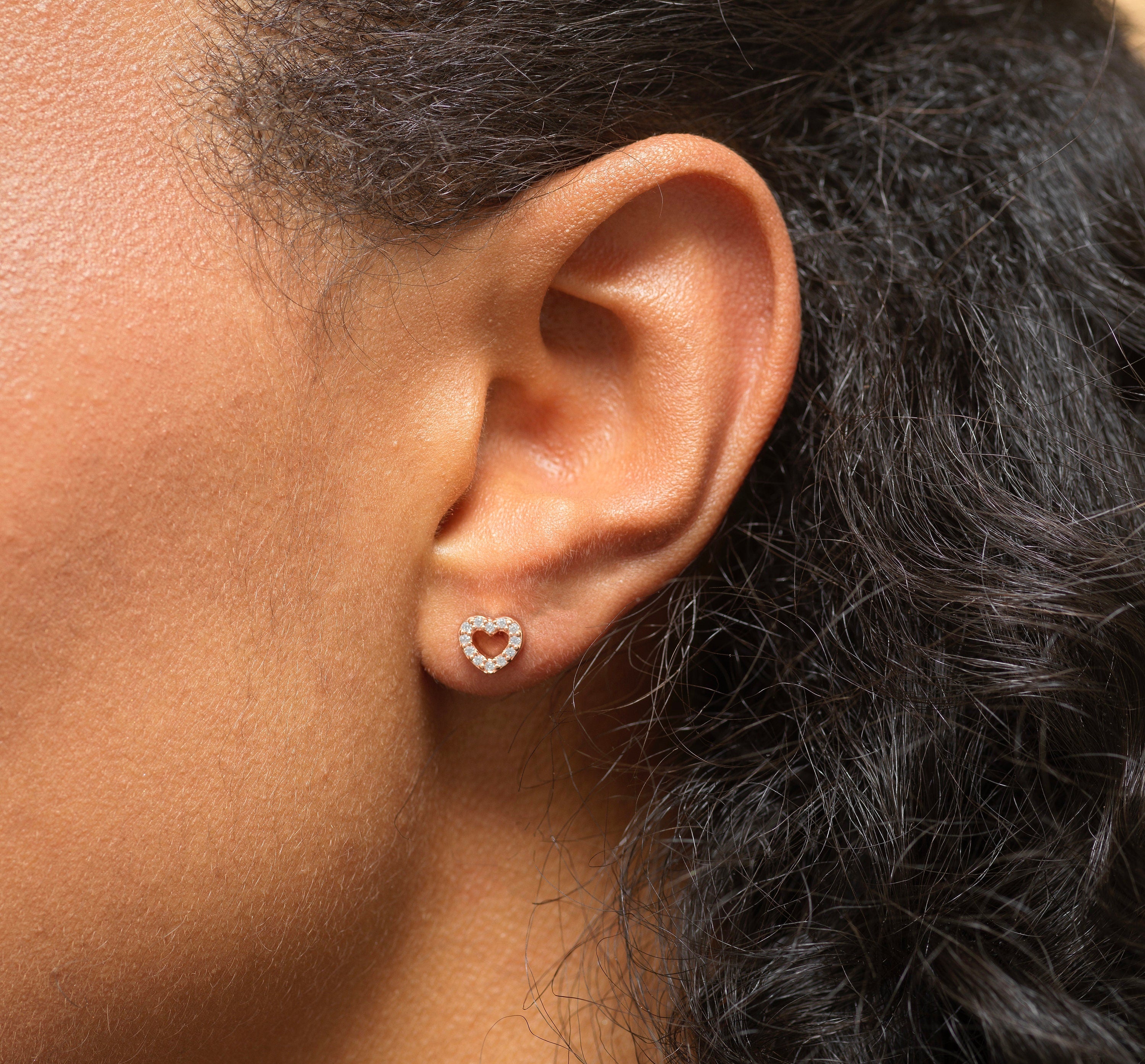 Model wearing Bijou Betty’s 925 silver heart stud earrings, 6mm x 7mm, silver or gold plate, styled for everyday wear.