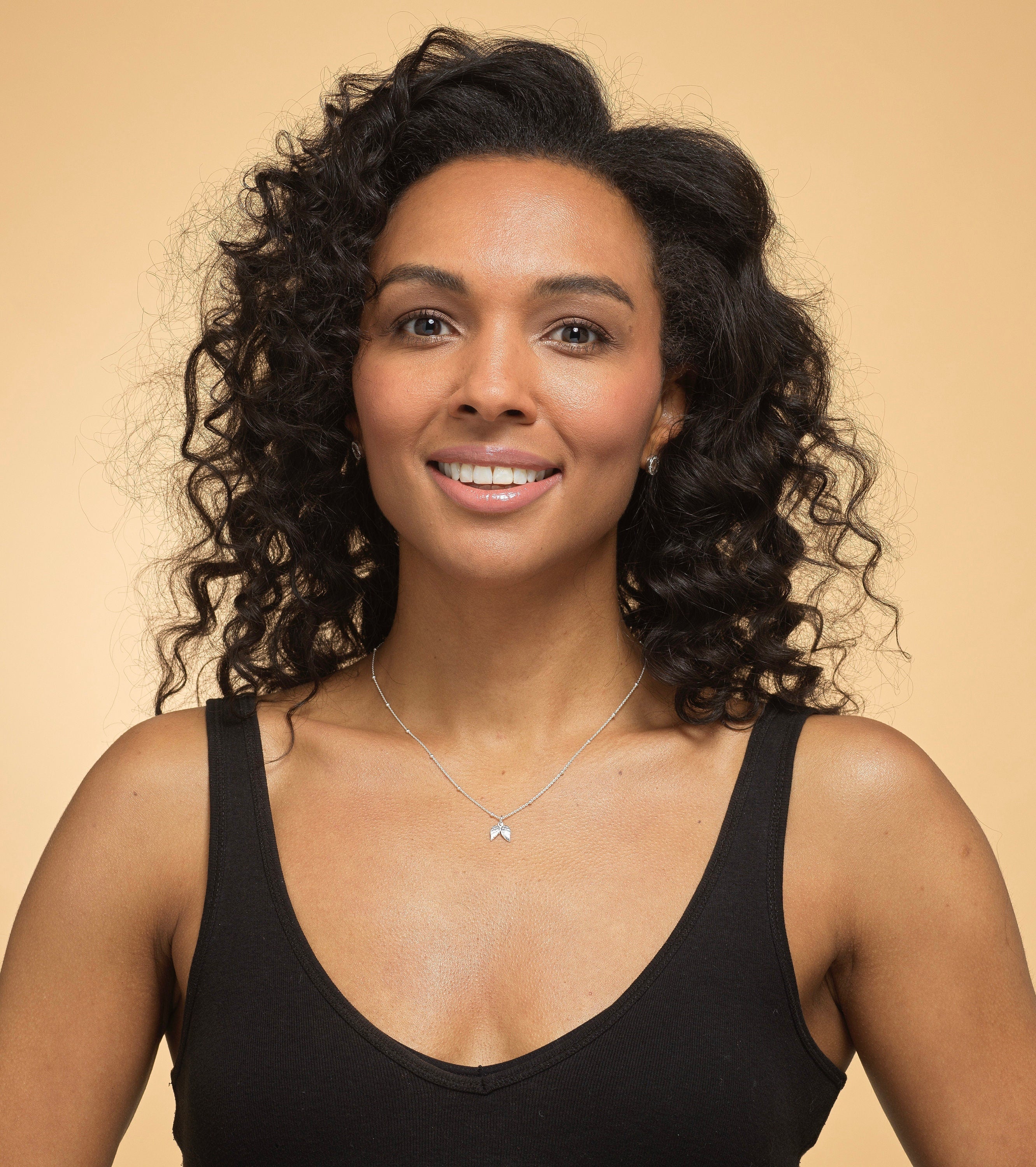 Model wearing Bijou Betty’s 925 silver angel wing necklace, 9mm x 10mm charm, styled for a comforting tribute.
