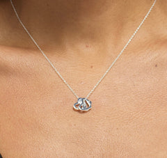 Close up of model wearing Bijou Betty’s 925 sterling silver 18th birthday necklace, featuring three 10mm hearts (“Live, Laugh, Love”) on a 16–18 inch adjustable chain, styled elegantly.