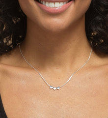 Close up of a model wearing sterling silver friend necklace.
