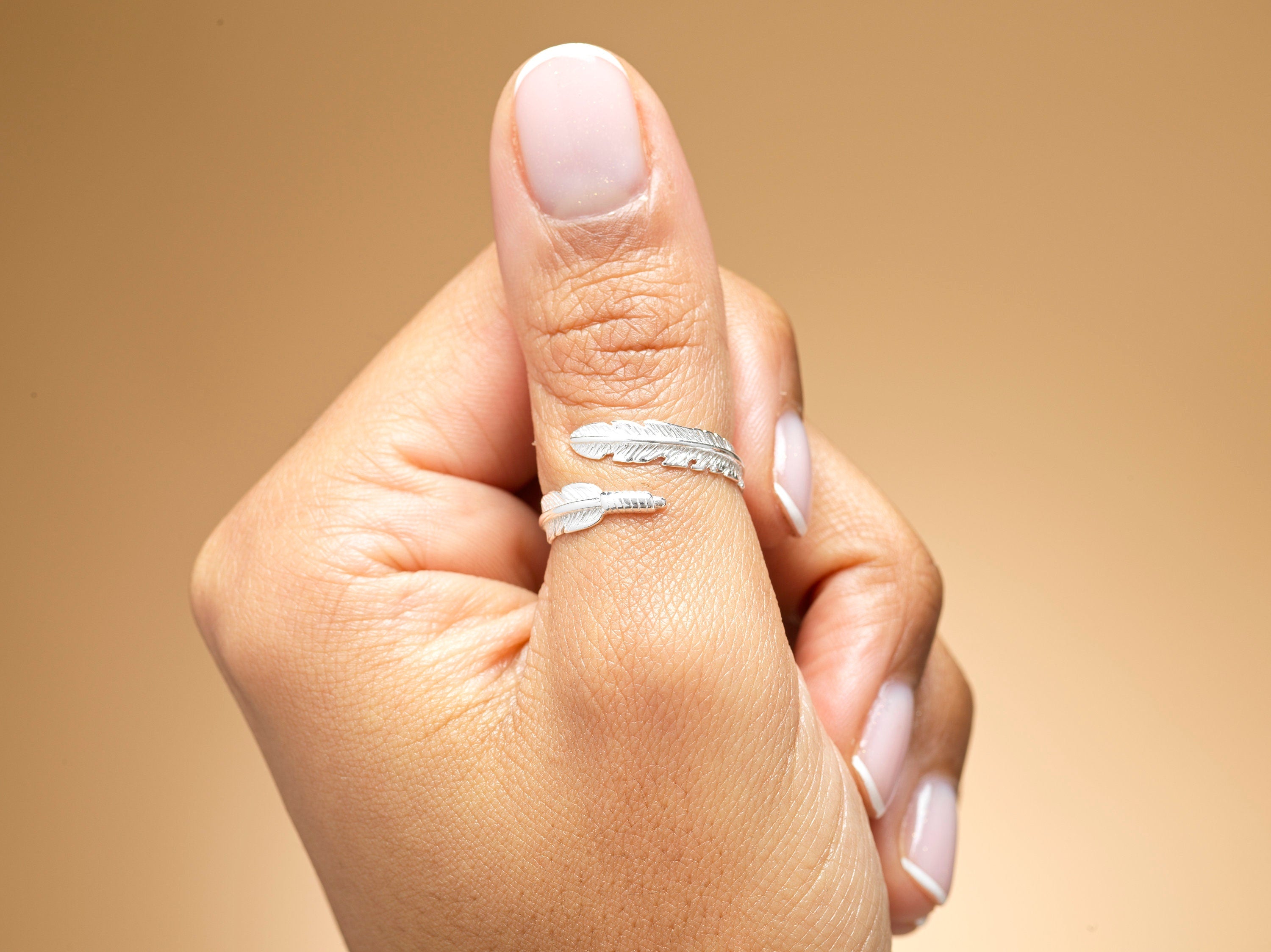 Model wearing sterling silver feather wrap ring.