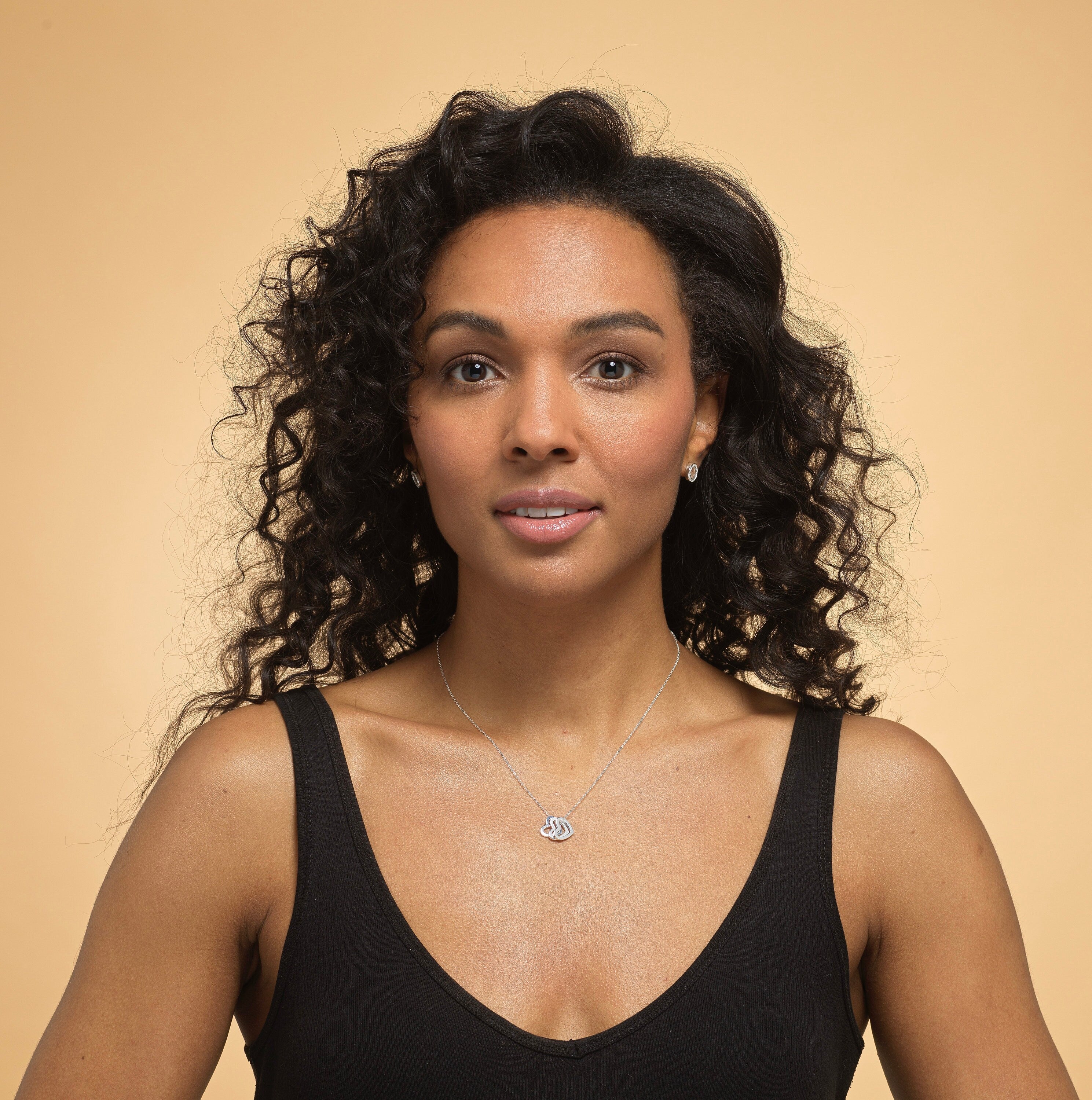 Model wearing Bijou Betty’s 925 sterling silver 18th birthday necklace, featuring three 10mm hearts (“Live, Laugh, Love”) on a 16–18 inch adjustable chain, styled elegantly.
