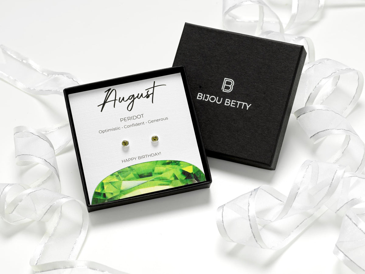 Sterling silver August birthstone earrings with 4mm peridot cubic zirconia. Perfect gift for daughter, sister, granddaughter, niece, or friend. Includes gift box, bag, tissue, and card highlighting traits: optimistic, confident, generous.