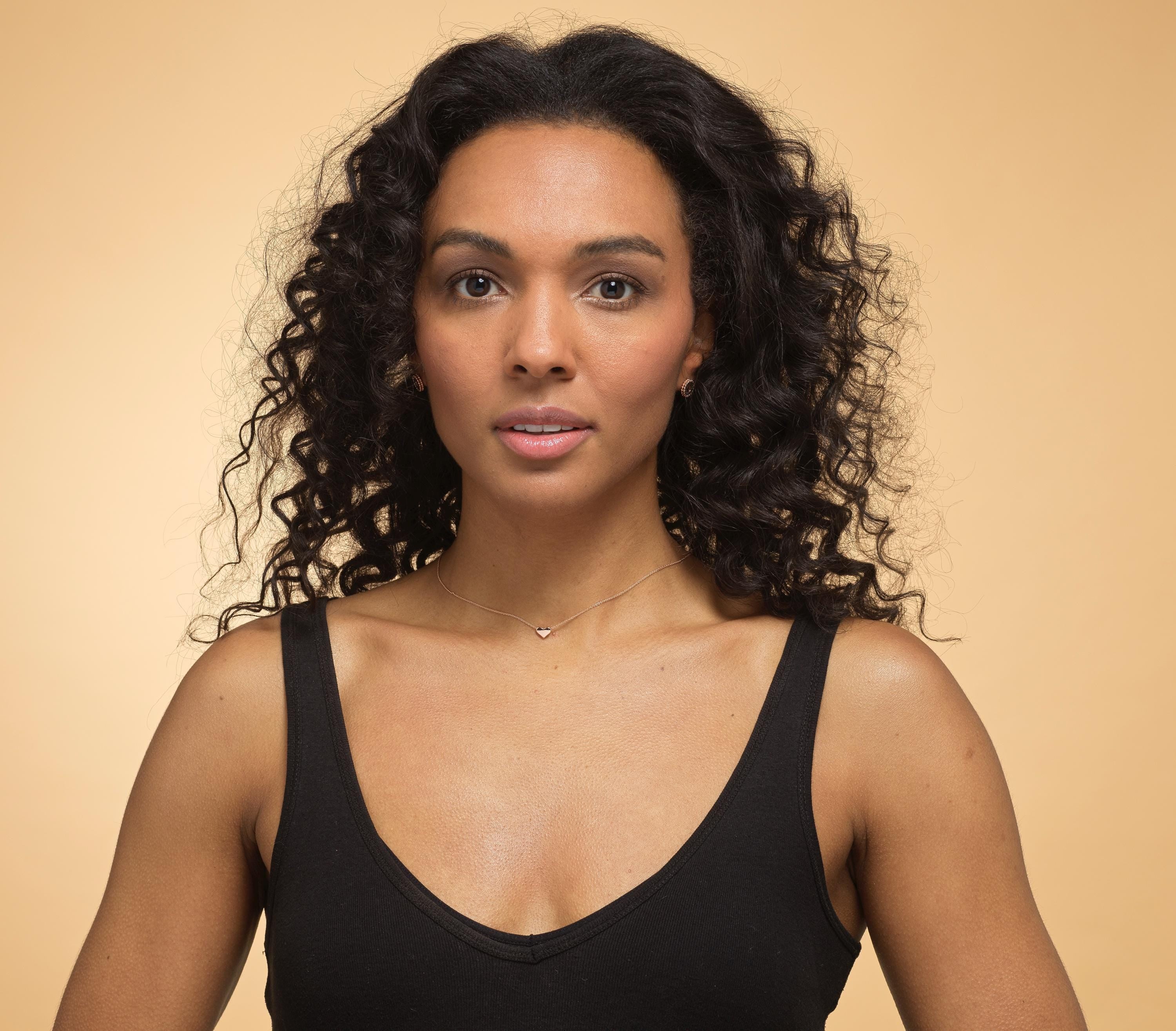 Model wearing rose gold daughter heart necklace.