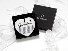 Ceramic heart keepsake with a black satin ribbon, featuring the heartfelt quote, Grandma - The one who has the warmest heart and gives the biggest hugs.  perfect for birthdays, Christmas, or as a sentimental gift for a cherished grandmother.