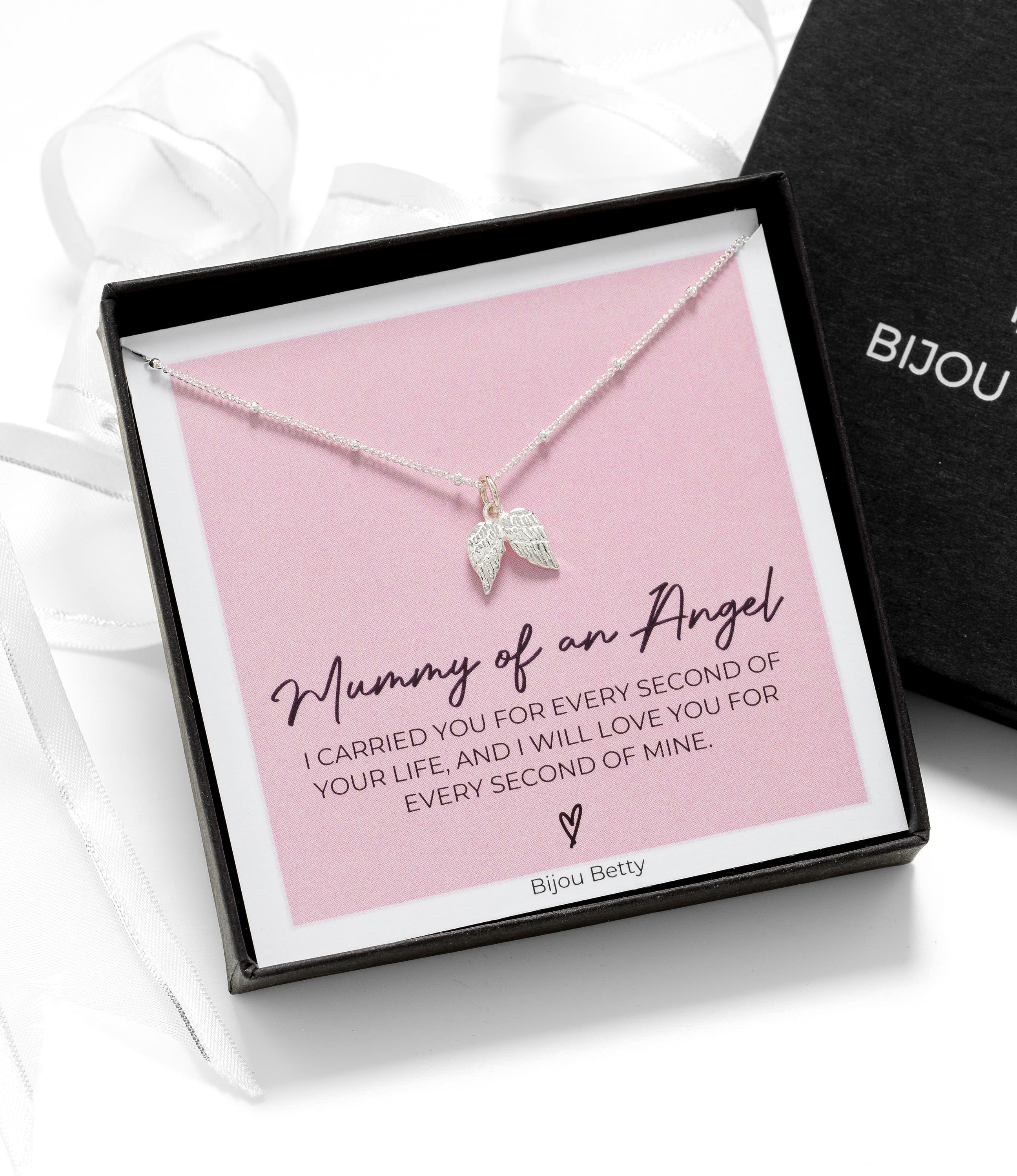 Close up of Bijou Betty’s sympathy gift set, 925 silver angel wing necklace in gift box with bag, tissue, and card.