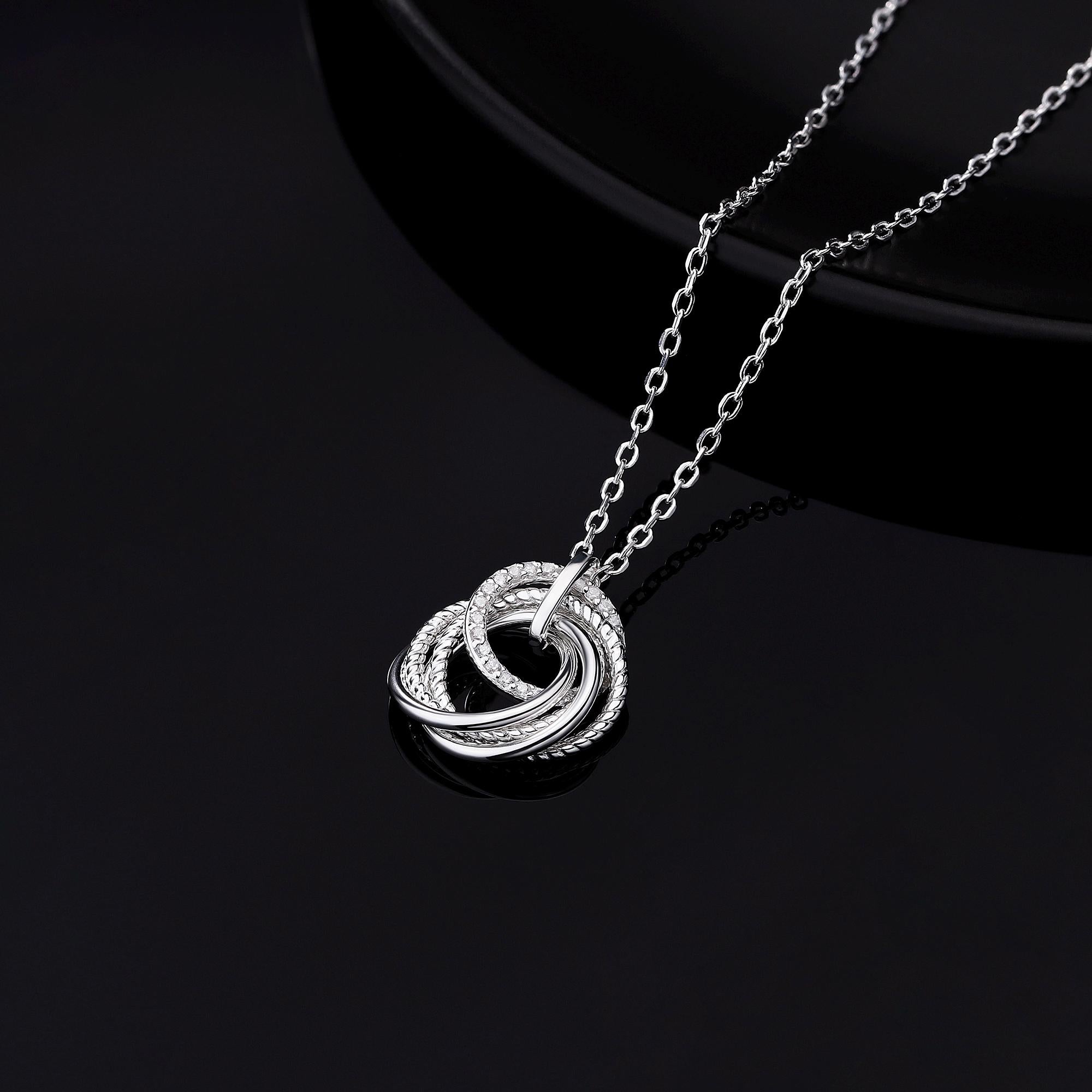 Close-up of a 925 sterling silver 5 ring decades necklace with five interlocked rings, one featuring sparkling cubic zirconia stones, on a white background.