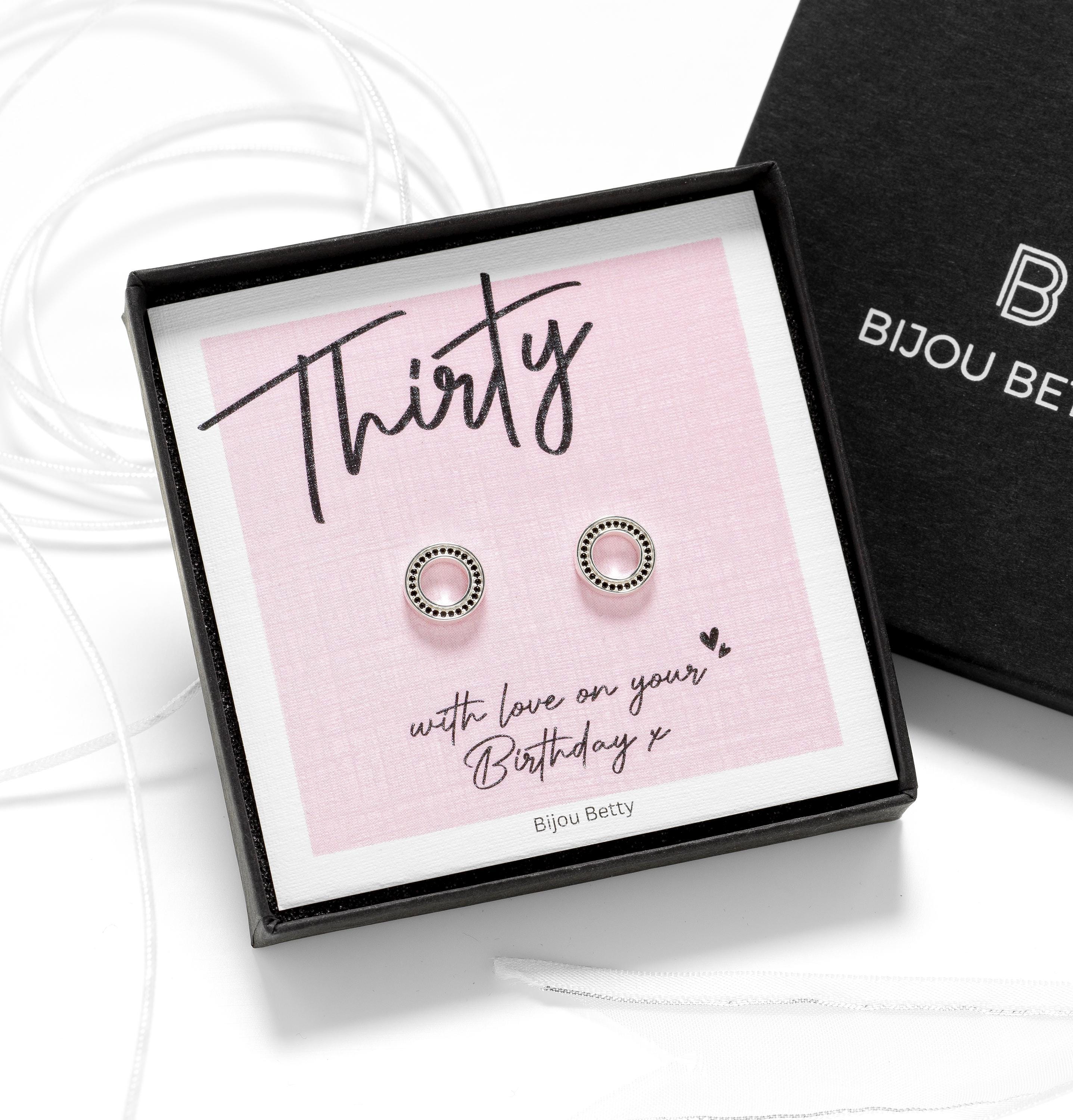 Close up of 30th birthday jewellery—silver open circle studs with black cubic zirconia studs.