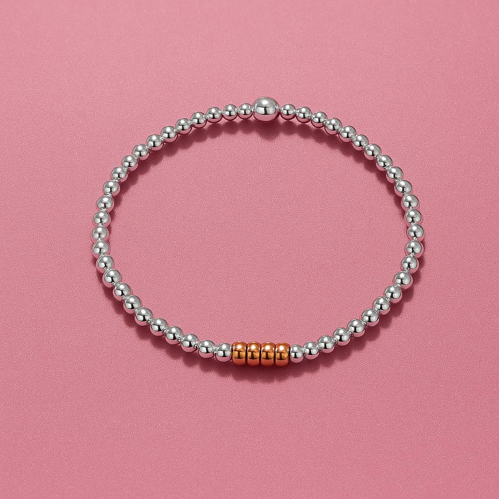 Close-up of Bijou Betty’s 925 silver and rose gold decades bracelet, 3mm silver beads, 4mm rose gold rings, stretch-fit.