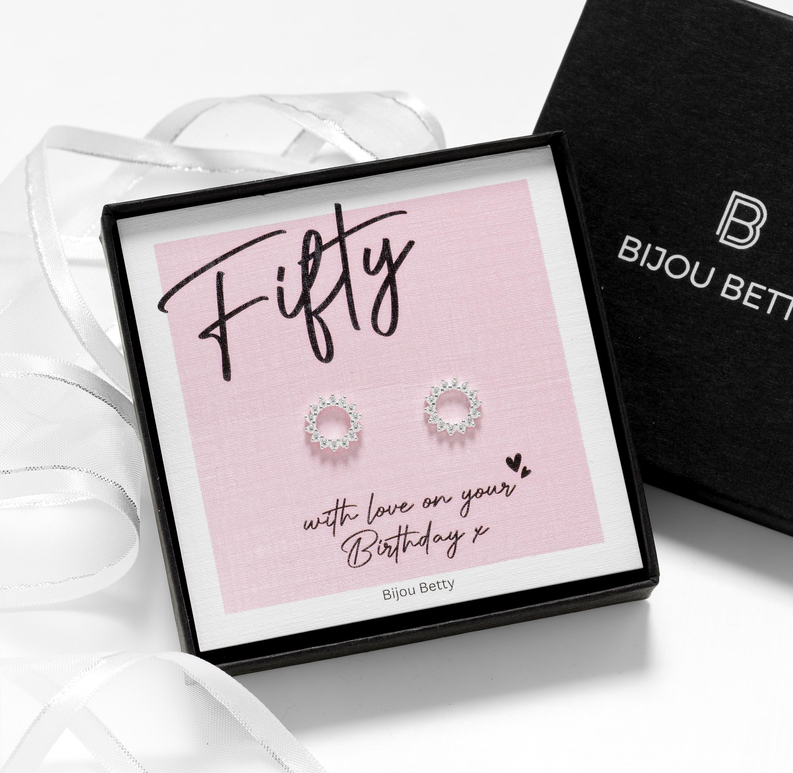 Close up of 50th birthday jewellery—sterling silver cubic zirconia stud earrings, in a gift box and card.