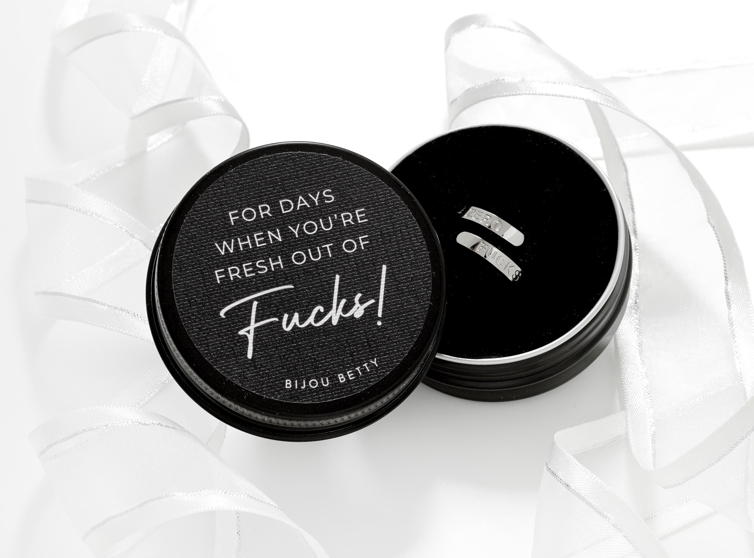 Close up of Bijou Betty’s funny gift set, stainless steel ZERO FUCKS ring, in gift box with quote: FOR DAYS WHEN YOU’RE FRESH OUT OF FUCKS.