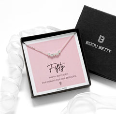 Close-up of 925 silver necklace with five dainty hearts, ideal for 50th birthday gifts for daughters or sisters.