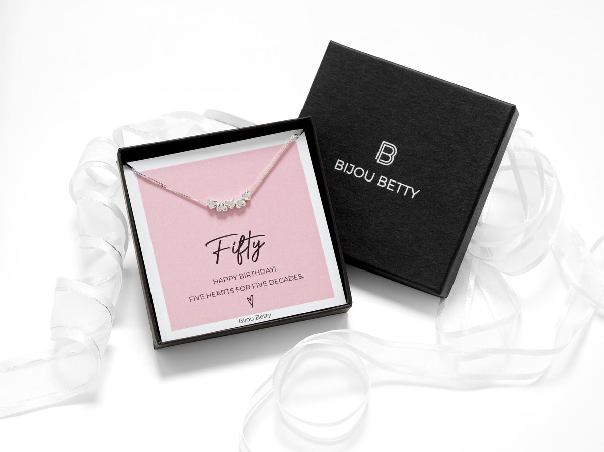 Bijou Betty 50th birthday necklace with tissue, card, and personalised tag, perfect for milestone celebrations.