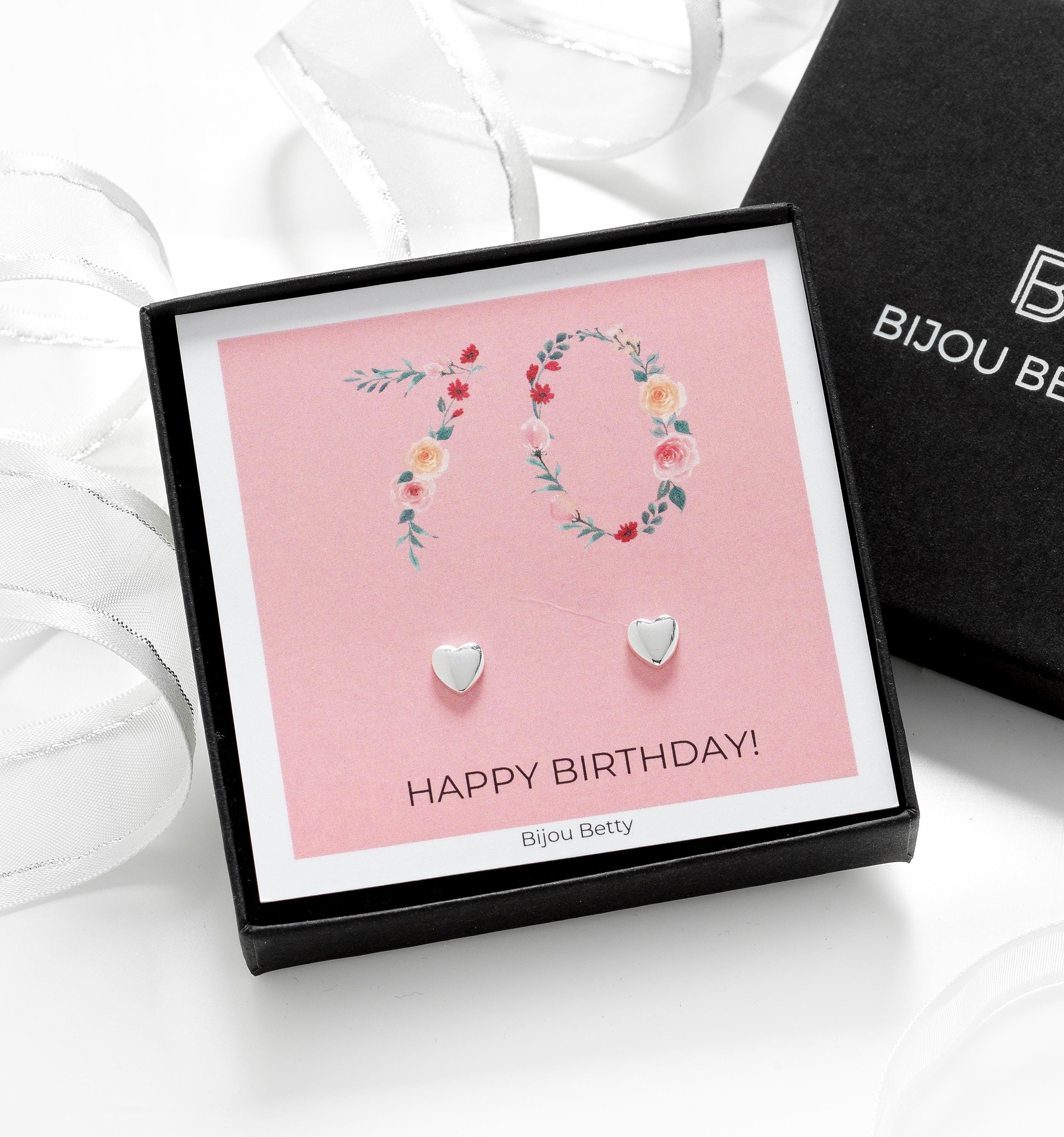 Close-up of silver heart earrings, perfect for 70th birthday gifts for mums or sisters.